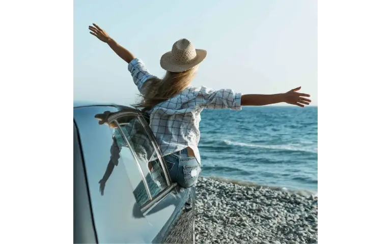 Slobodna žena Žena iz automobila širi ruke kao znak slobode