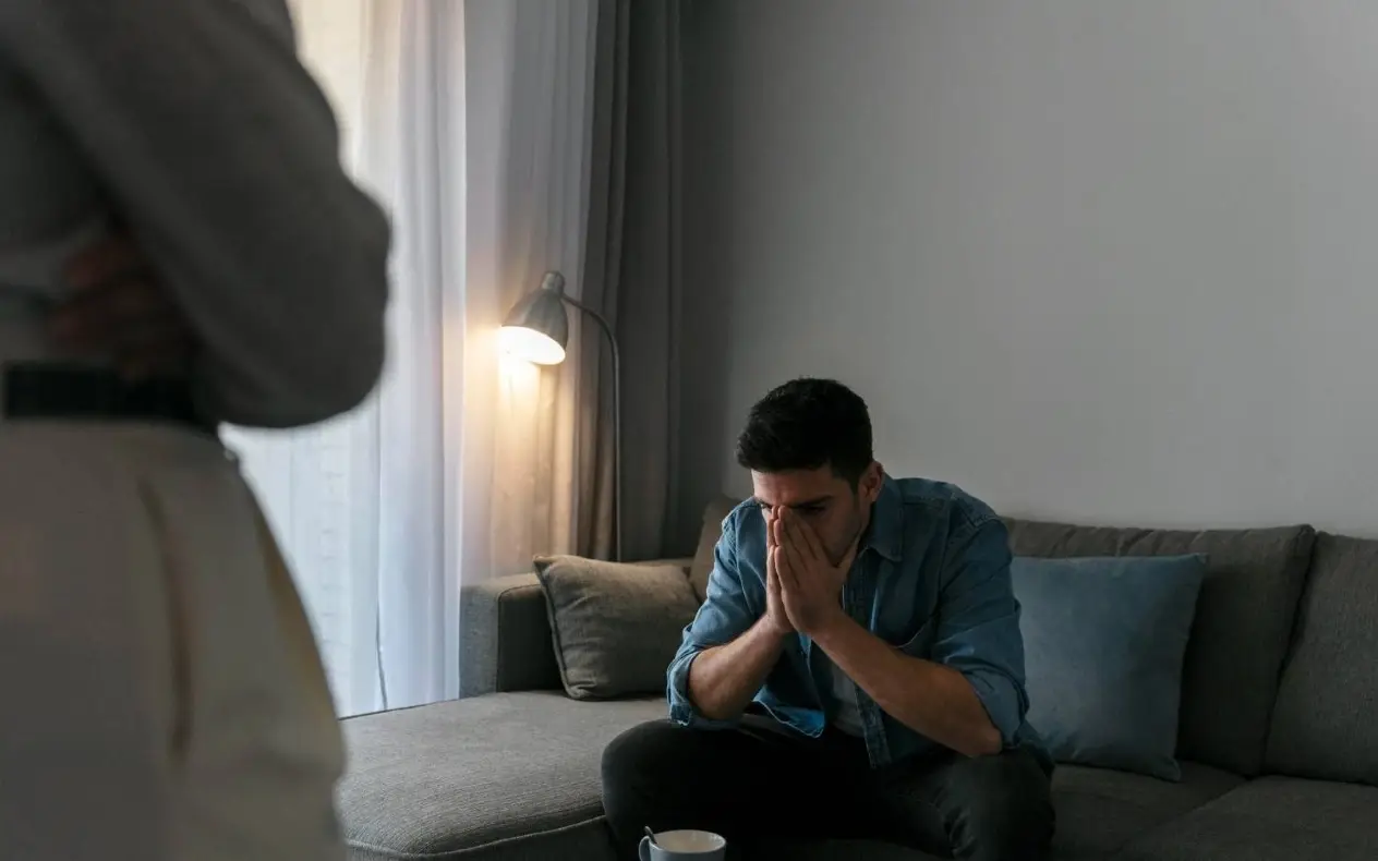 Muškarac sa skrštenim rukama preko lica 