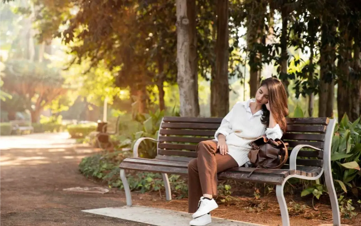 Zamišljena žena sedi na klupi