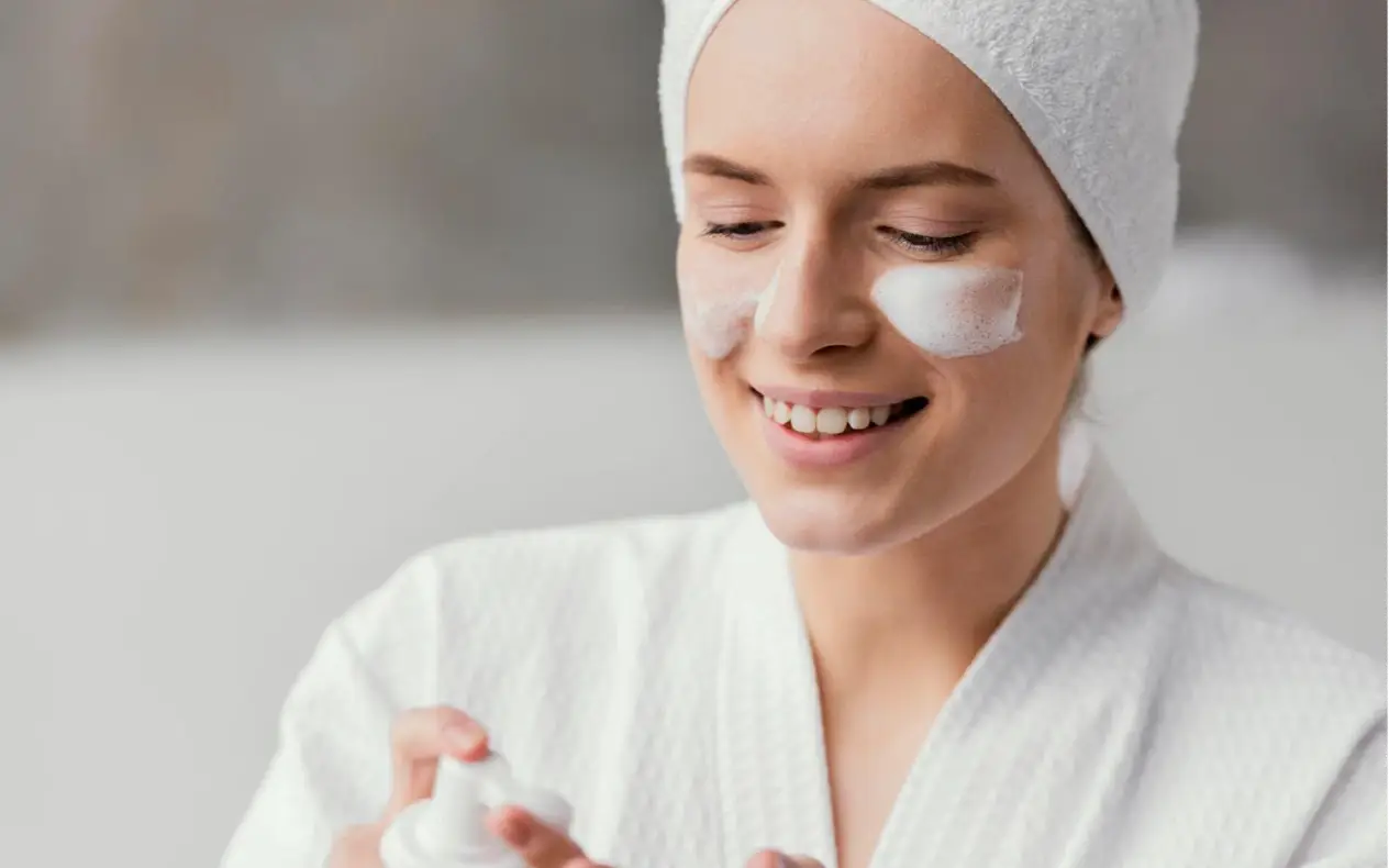 Tonirana hidratantna krema kod kuće u maloj posudi pored ogledala i beauty proizvoda Minimalistički beauty setup prikazuje domaću toniranu kremu u maloj staklenoj posudi, uz prirodno svetlo i proizvode za negu kože.