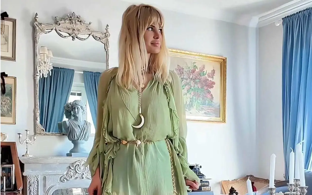 Carolina Miškić u svetloj boho haljini ukrašena dekorativnim nakitom sa pogledom u stranu