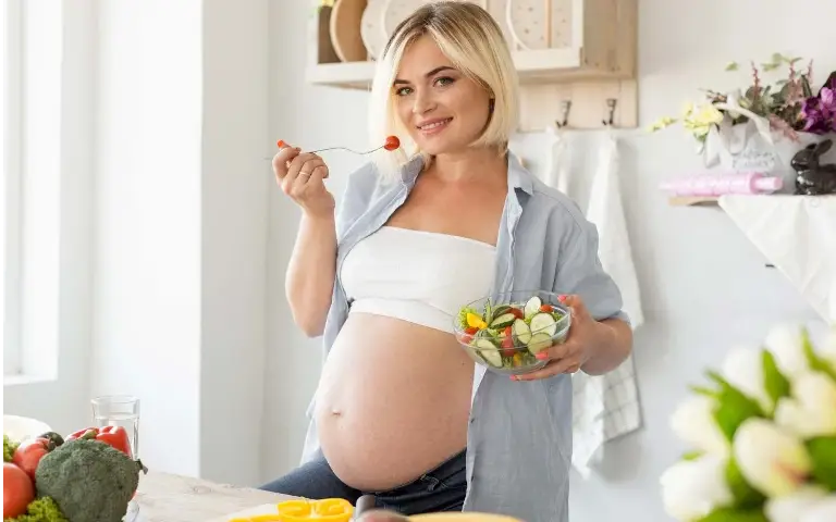 Trudna žena Trudna žena jede zdravu hranu nasmejana i srećna