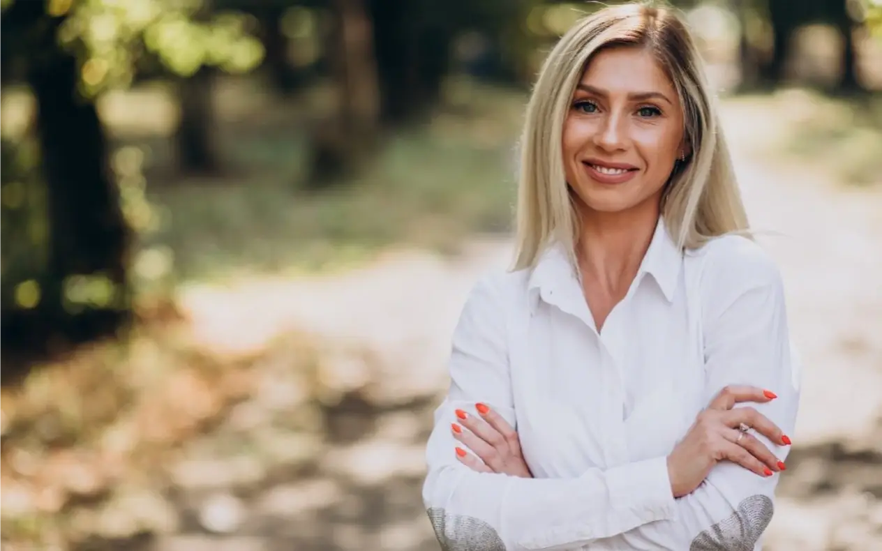 Žena srednjih godina gleda u kameru nasmejana i zadovoljna