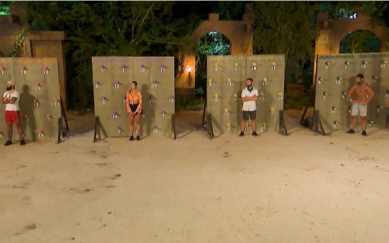 Četiri takmičara u Survivor izazovu stoje ispred zidova sa brojevima, pripremajući se za test izdržljivosti.