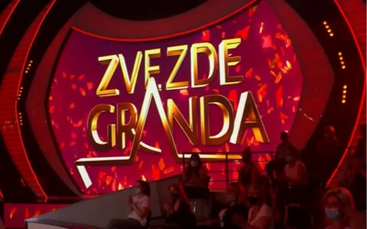 Scena muzičkog takmičenja "Zvezde Granda" sa osvetljenim logotipom i publikom u pozadini.