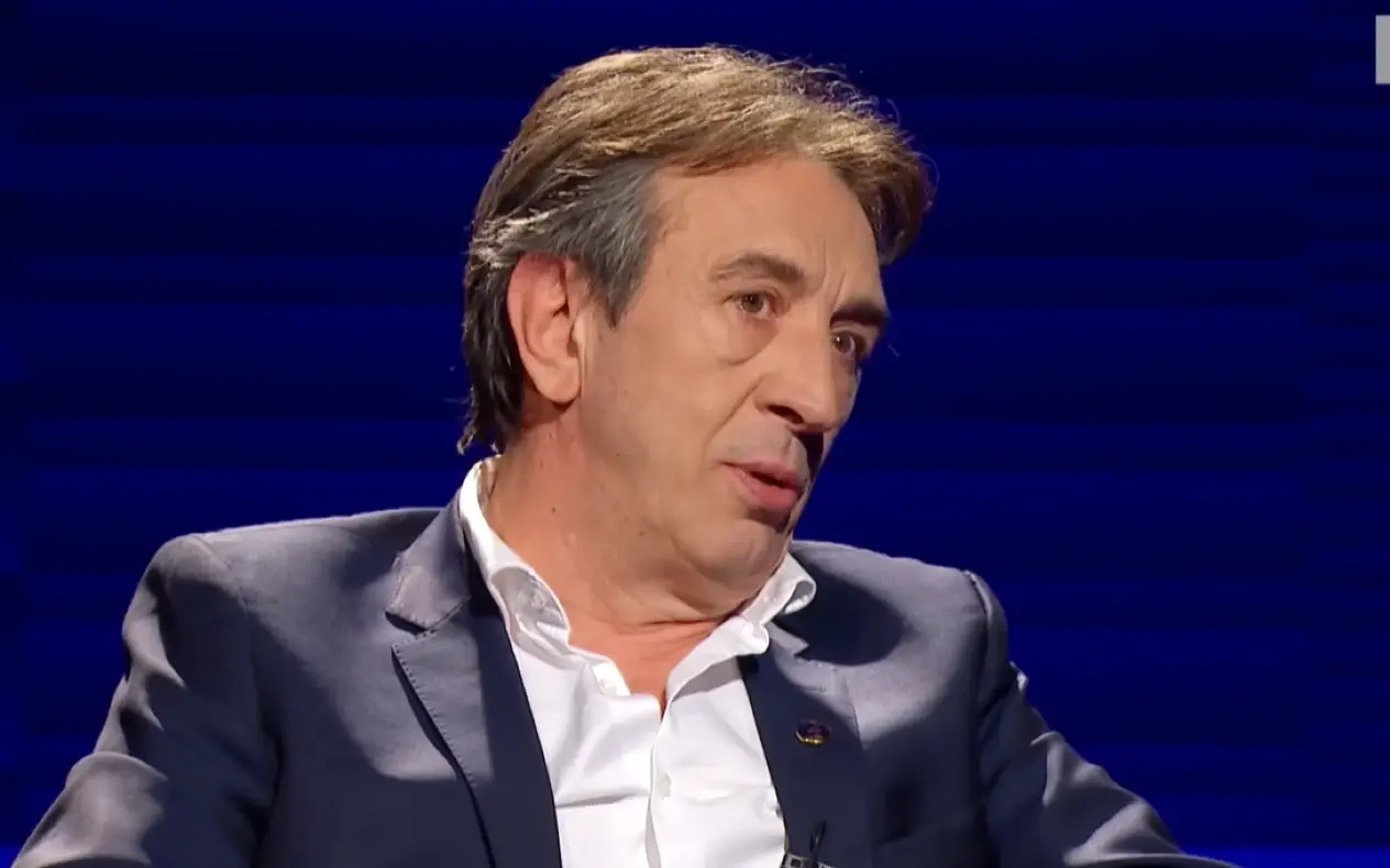 Žika Jakšić u teget odelu i beloj košulji sa blagim osmehom na licu tokom gostovanja u emsijii