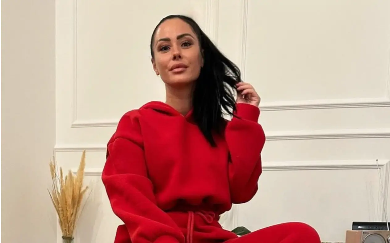 Aleksandra Bursać u crvenoj trenerci do sedi na stolu 
