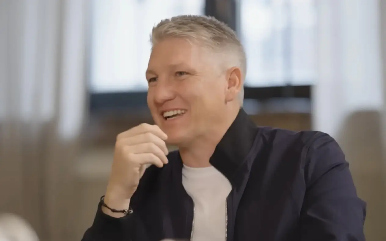 Bastian Schweinsteiger u beloj majici i teget košulji tokom razgovora sa voditeljem