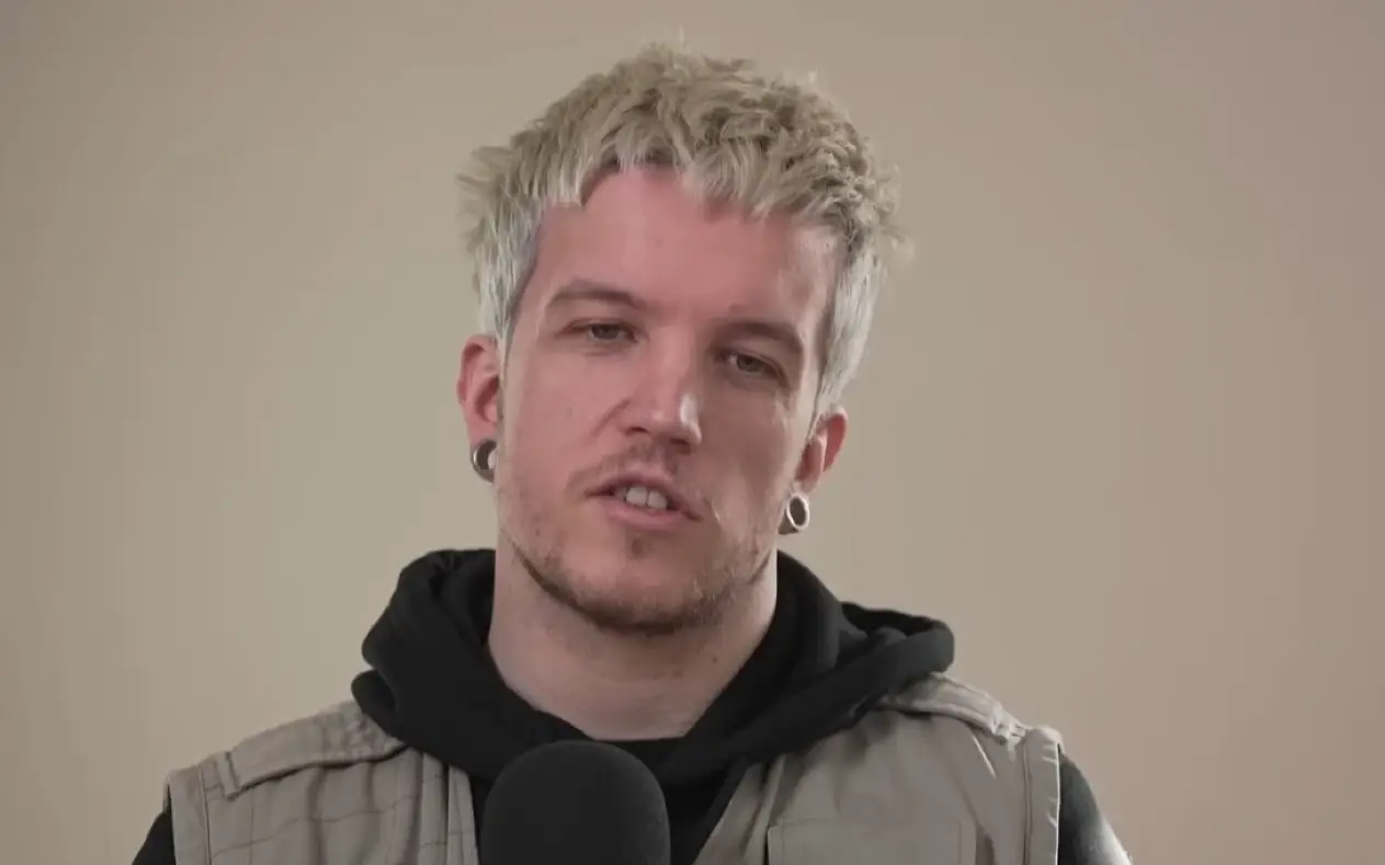 Baby Lasagna emisiji Baby Lasagna u sivom prsluku i crnoj dukserici sa kapuljačom tokom gostovanja u podcastu