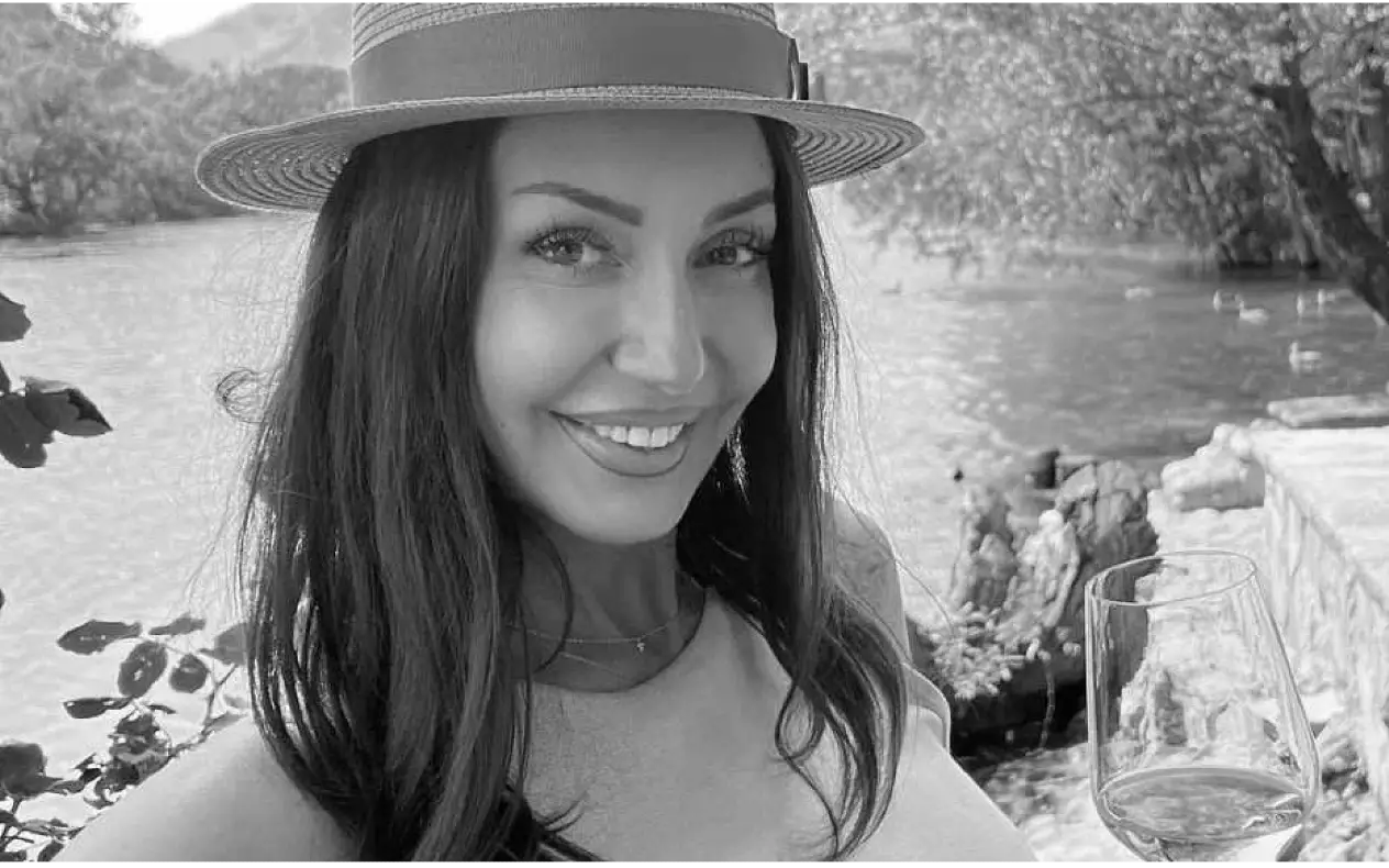 Danijela Boračeva crno bela slika, nasmejana i sa šeširom na glavi drži čašu vina