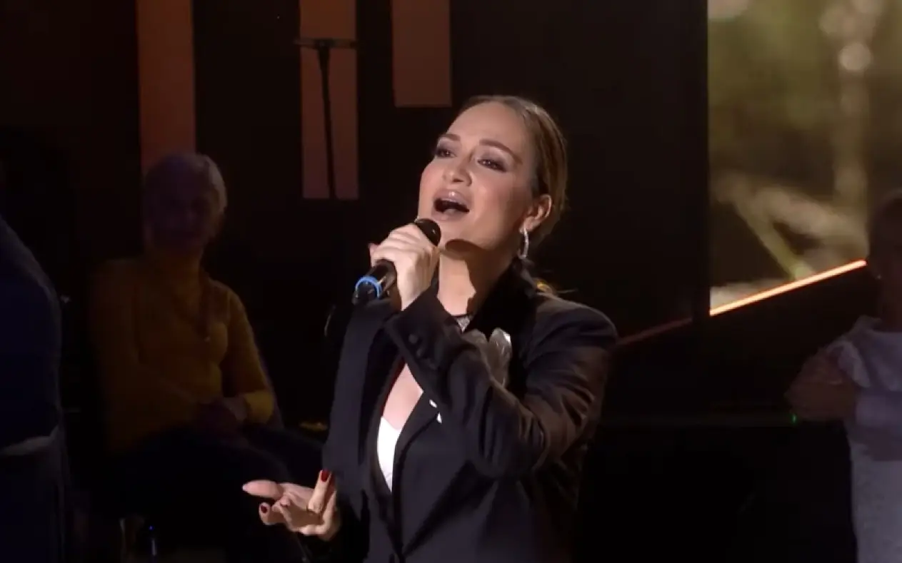 Jelena Tomašević sa blagom šminkom i ozbiljnim izrazom lica dok peva na sceni