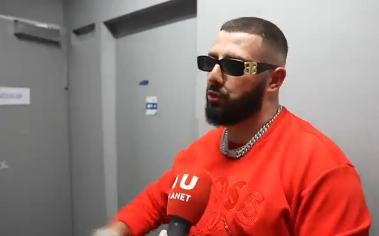 Sajfer u crvenoj majici i sa zlatnom kajlom oko vrata toko intervjua