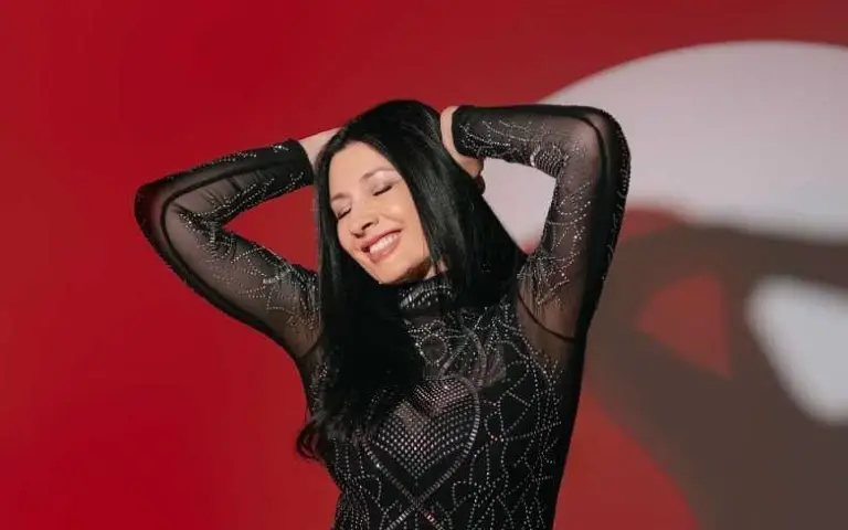 Kaliopi nasmejana sa rukama raširenim na glavi razmišlja zatvorenih očiju