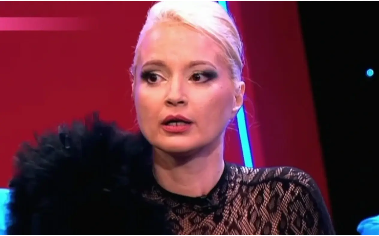 Maja Nikolić u studiju tokom televizijskog gostovanja, u elegantnoj crnoj čipkastoj haljini.