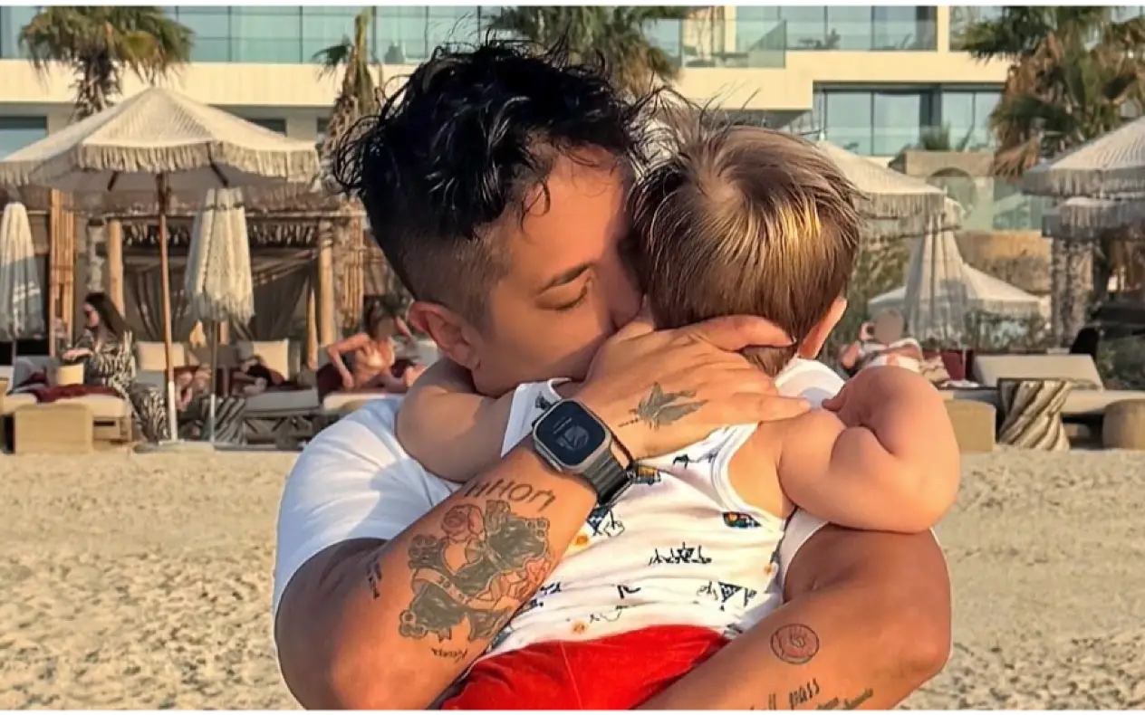 Marija Šerifović dok čvrsto na plaži grli sina koji ima plavu kosu, crveni šorc i šaernu majicu
