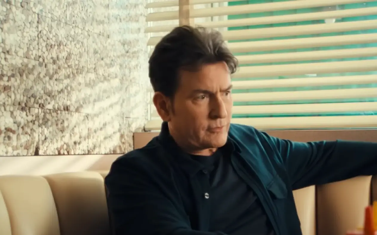 Charlie Sheen u teget košulji i sa ozbiljnim izrazom lica