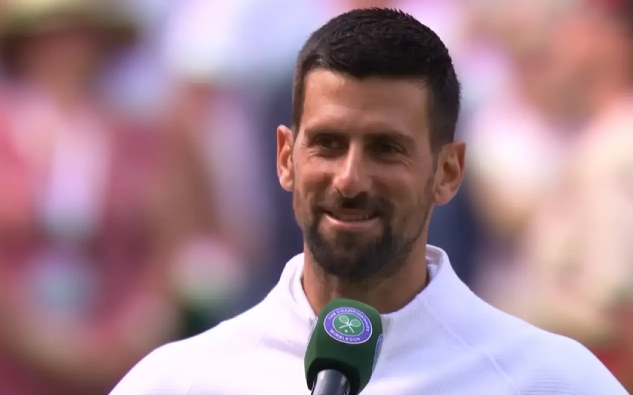 Novak Đoković intervju nakon pobede Novak Đoković u beloj trenerci sa osmehom na licu nakon pobede nad Danom Evansom