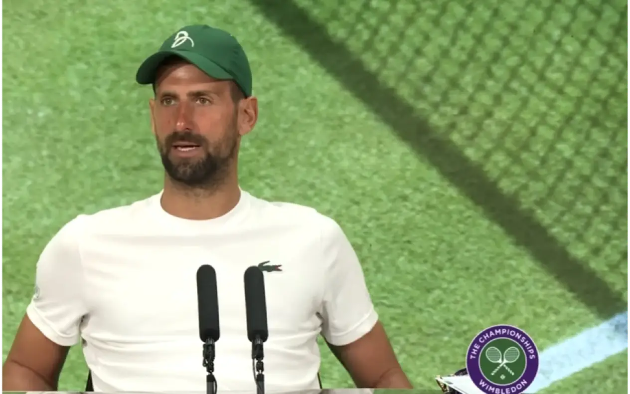 Novak Đoković u beloj majici i sa zelenim kačketom na glavi tokom konferencije