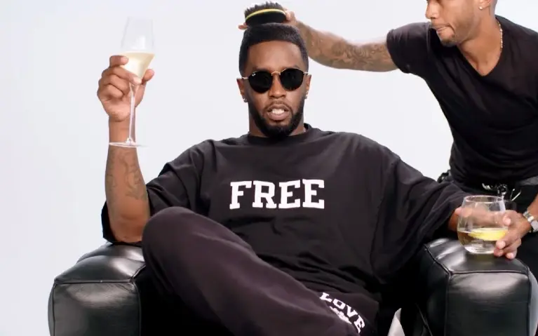P. Diddy u fotelji sa čašom šampanjca u ruci dok se frizira