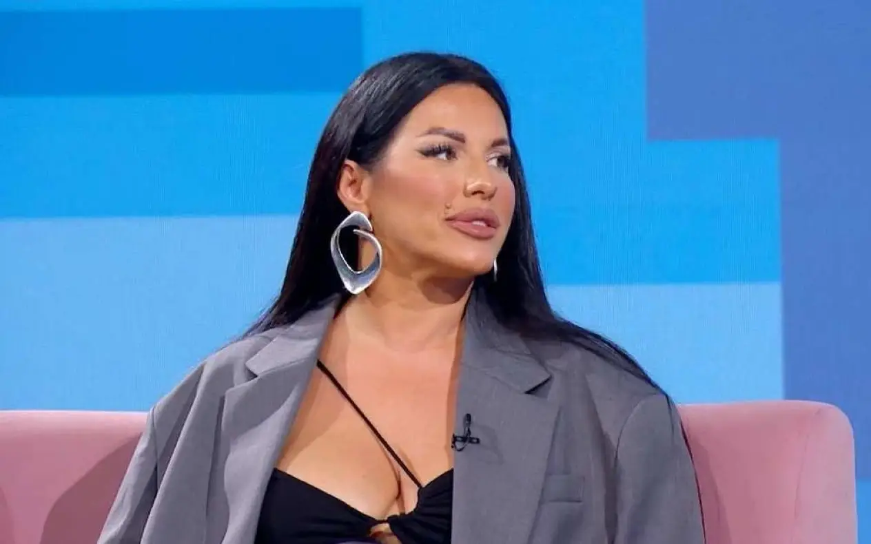 Seka Aleksić u sivom sakou i izrazito velikim srebrnim minđušama iz profila dok sedi u studiju tv emisiji