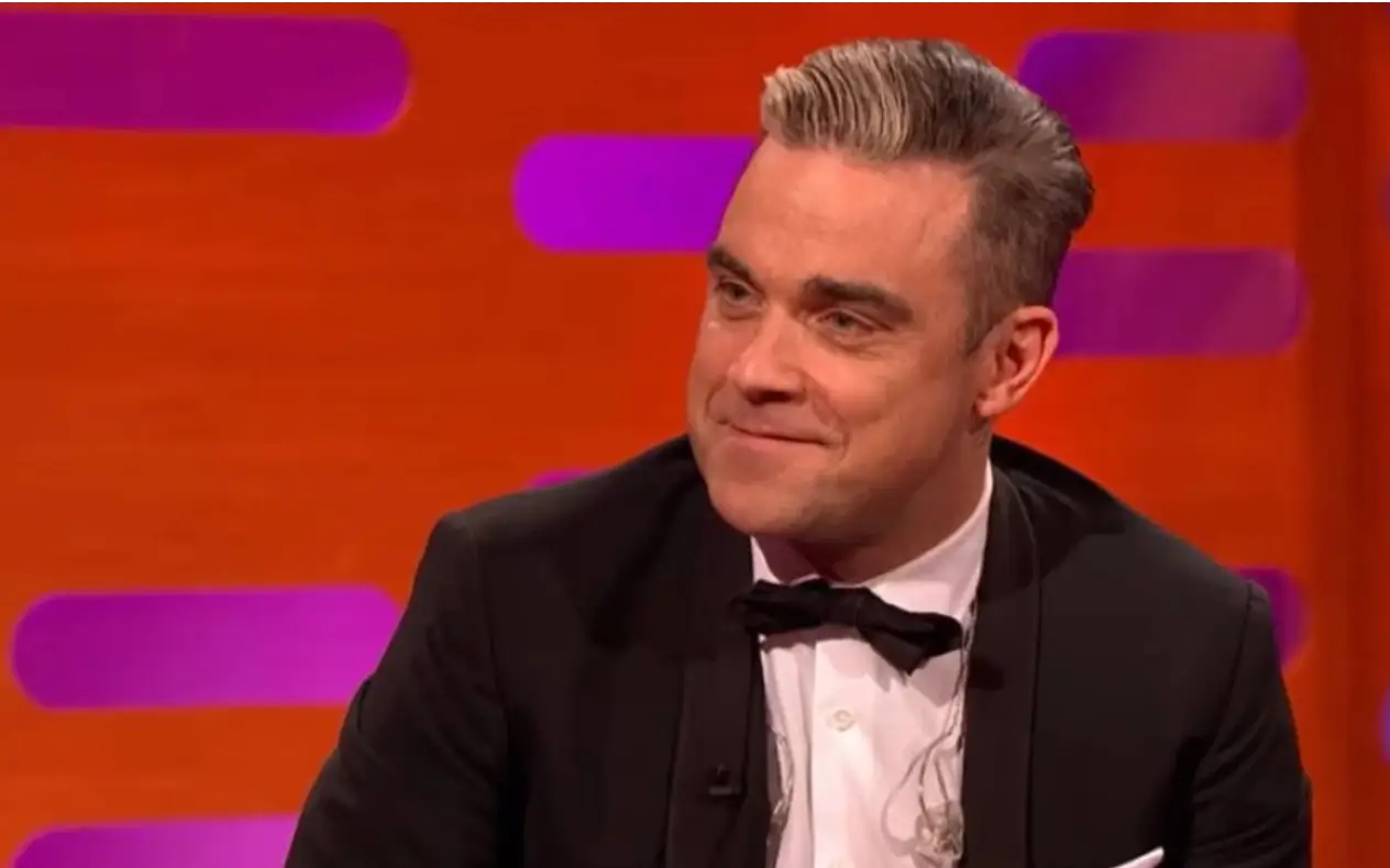 Robbie Williams tokom gostovanja u emisiji sa blagim osmehom na licu