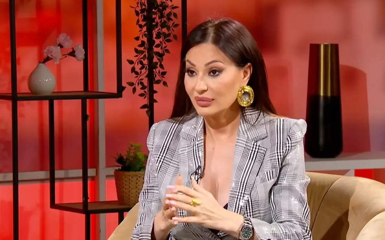 Ceca Ranatović u emisiji sa širokim osmehom na licu, izraženom šminkom i upečatljivim nakitom
