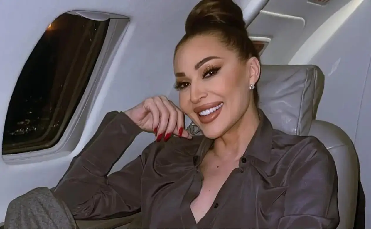 Ceca Ranatović u avionu Ceca Ranatović u braon odelu u avionu sa širiokim osmehom na licu