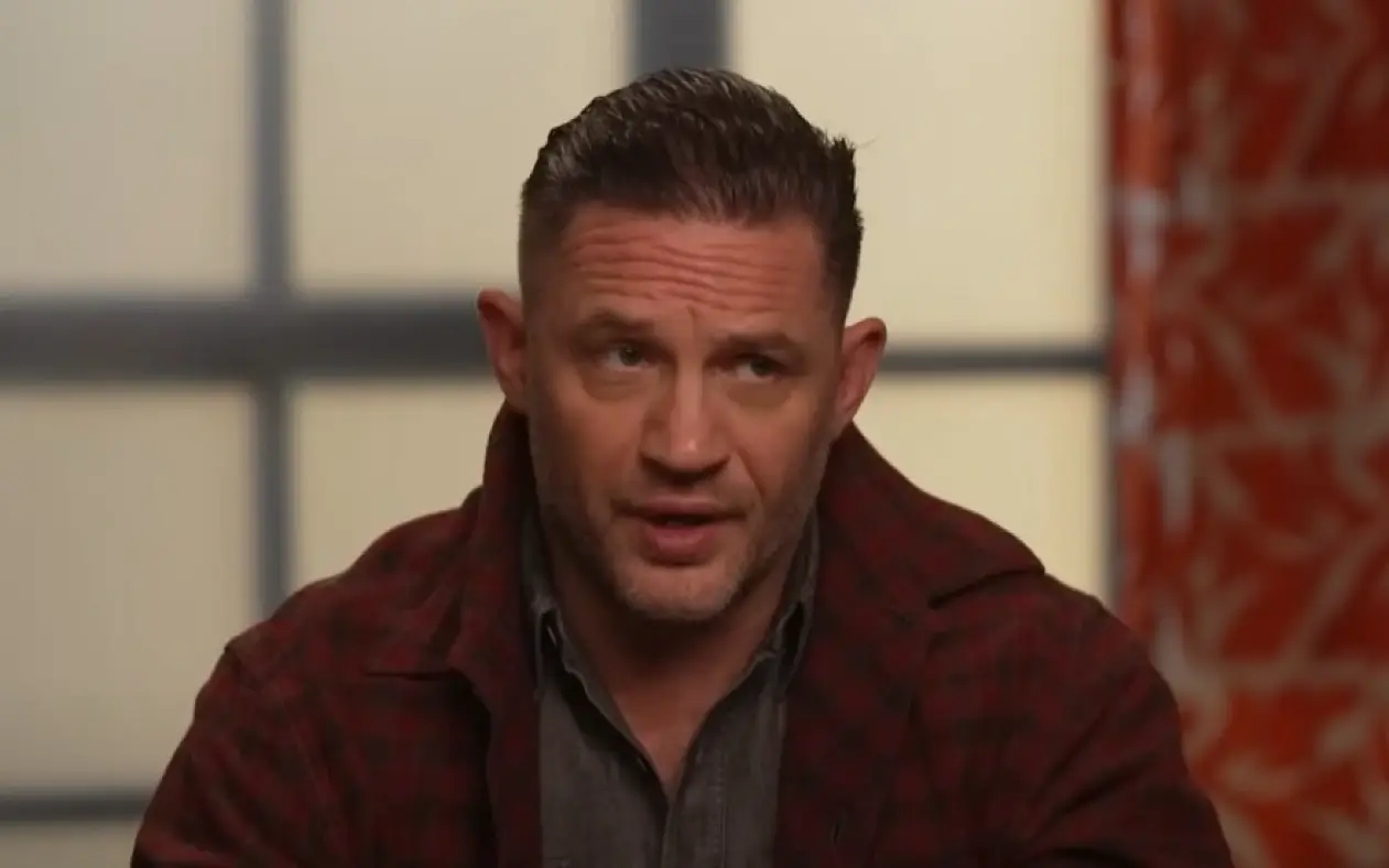 Tom Hardy u crvenoj jakni sa ozbiljnim izrazom lica tokom gostovanja u emisiji