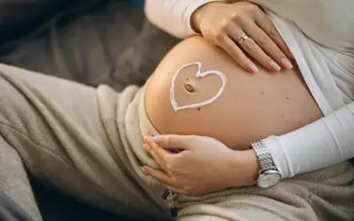 Trudna zena  drži ruke na stomaku na kome je nacrtano srce