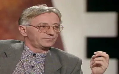 Oliver Dragojević u TV emisiji Oliver Dragojević u šarenoj košulji i sivom odelu sa ozbiljnim izrazom lica tokom gostovanja u emisiji