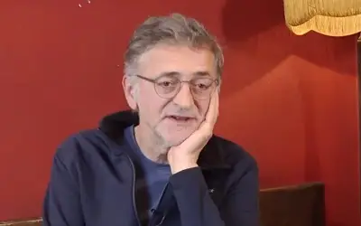 Zoran Cvijanović, naočari, teget duks, crvena pozadina Zoran Cvijanović sa naočarima u teget duksu