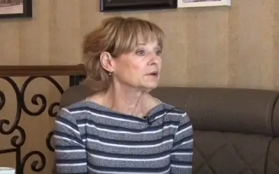 Zlata Numanagić u šarenoj bluzi, sedi u kafiću tokom davanja intervjua