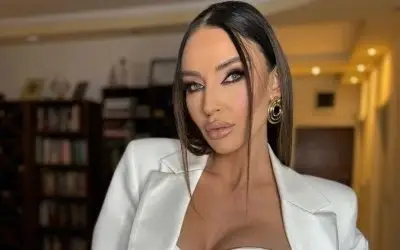 Katarina Živković u belom odelu sa izrazitom šminkom i zlatnim nakitom