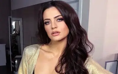 Milica Pavlović pozira u zlatnoj majici i sa jakom šminkom