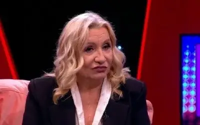 Vesna Zmijanac sa ozbiljnim izrazom lica u crnom sakou i beloj košulji tokom gostovanja u emisiji
