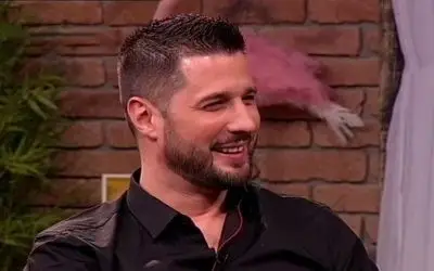 Marko Miljković u crnoj košulji tokom gostovanja u emisiji sa širokim osmehom na licu