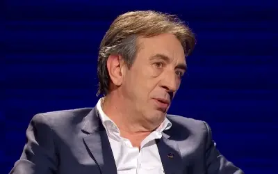 Žika Jakšić u TV emsijii Žika Jakšić u teget odelu i beloj košulji sa blagim osmehom na licu tokom gostovanja u emsijii