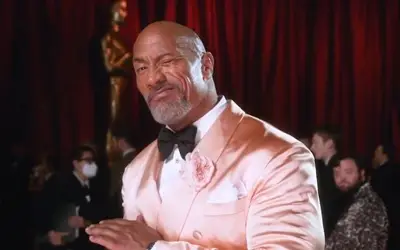 Dwayne Johnson tokom dodele Oskara Dwayne Johnson u satenskom roze sakou