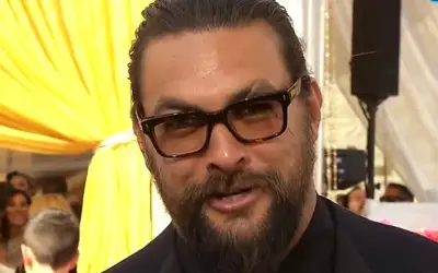 Jason Momoa na crvenom tepihu Jason Momoa sa osmehom na licu - brada, vezana kosa