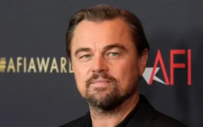 Leonardo DiCaprio u crnom sakou i košulji, sa bradom i brkovima