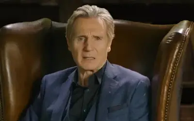 Liam Neeson tokom gostovanja u popularnoj emisiji Liam Neeson u plavom sakou i crnoj košulji, sedi u fotelji