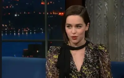 Emilia Clarke u tv emisiji Emilia Clarke u šarenoj haljini i sa crnom maramom oko vrata tokom gostovanja u emisiji