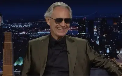 Andrea Bocelli u tv emisiji Andrea Bocelli u sivom sakou i teget košulji nasmejan tokom gostovanja u emsiji