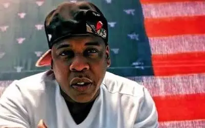 Jay Z sa kačketom na glavi i američkom zastavom u pozadini