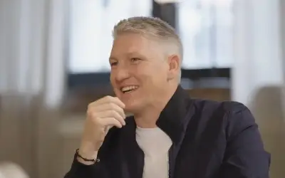 Bastian Schweinsteiger u tv emisiji Bastian Schweinsteiger u beloj majici i teget košulji tokom razgovora sa voditeljem