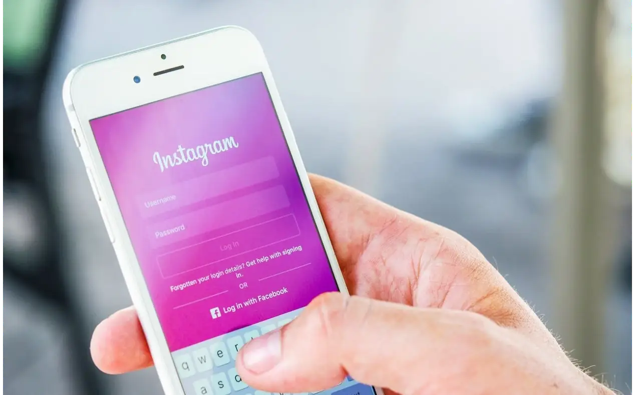 Aplikacija instagrama dok muškarac drži telefon u ruci pokušavajući da se uloguje na profil