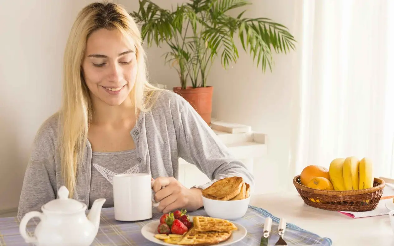 Devojka doručkuje i pije čaj