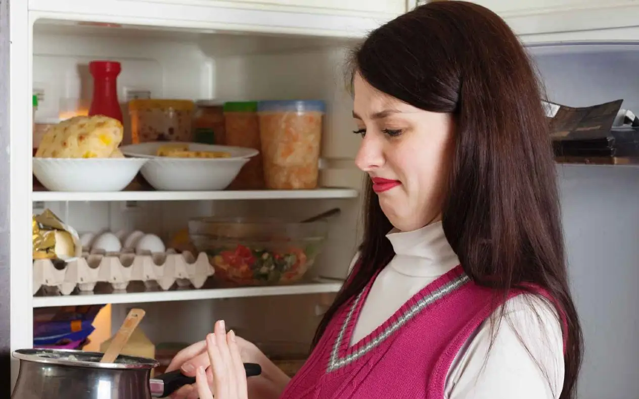 Žena sklanja ručak iz frižidera koji neprijatno miriše