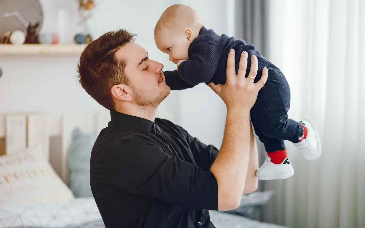 Otac u crnoj majici i beba 