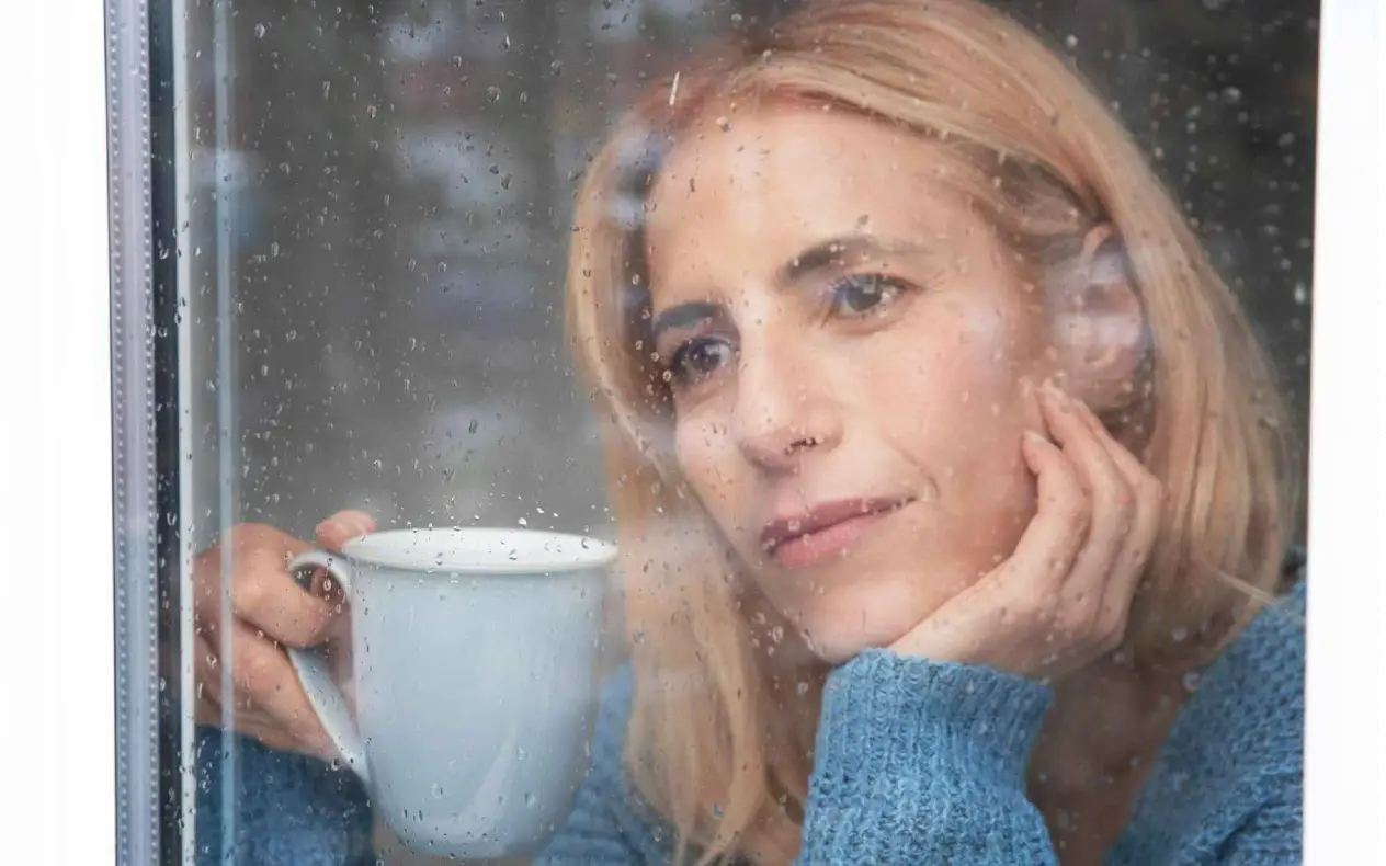 Žena zabrinuta gleda kroz prozor